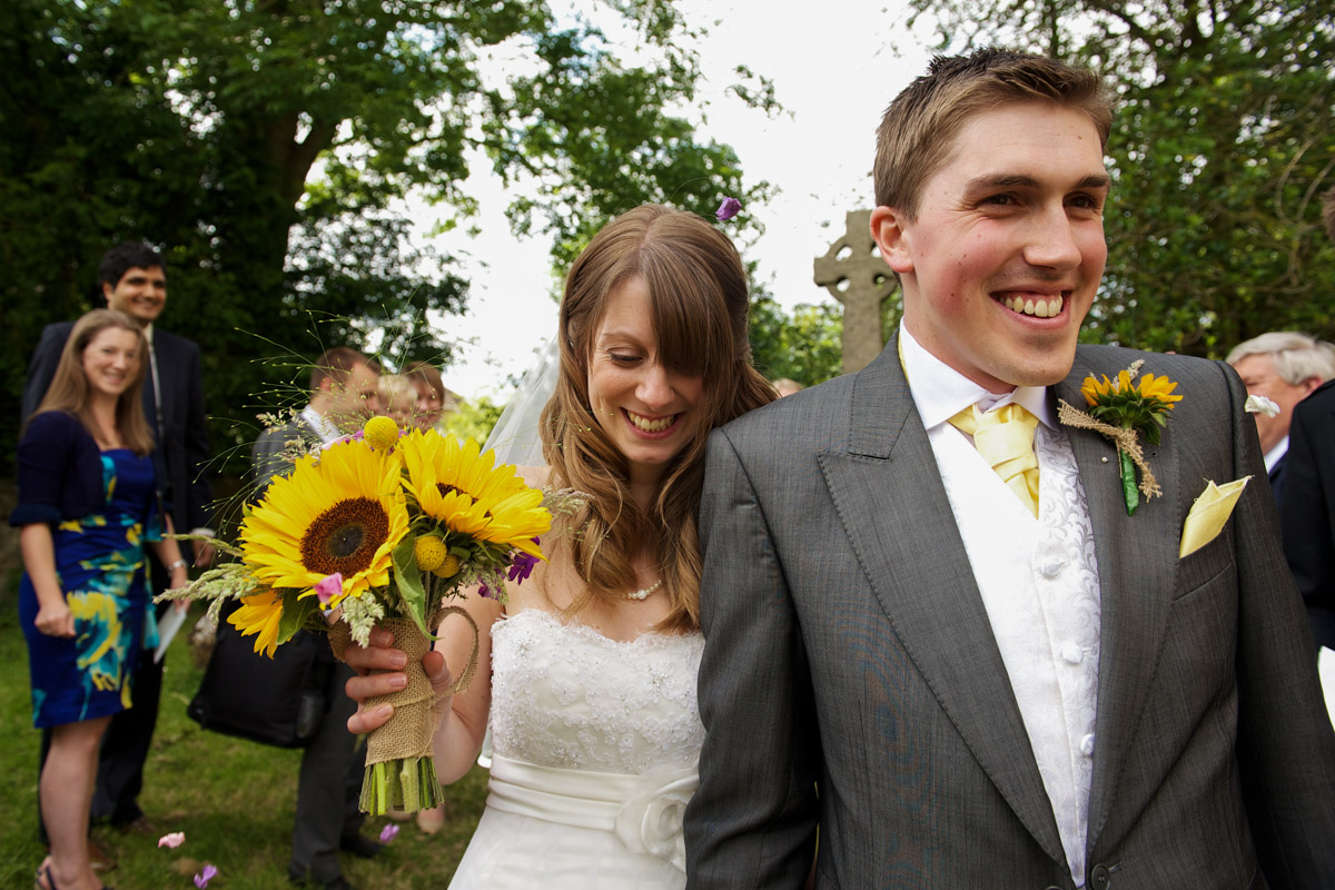 Laura and Adam are photographed leaving Egerton church after their Kent wedding ceremony