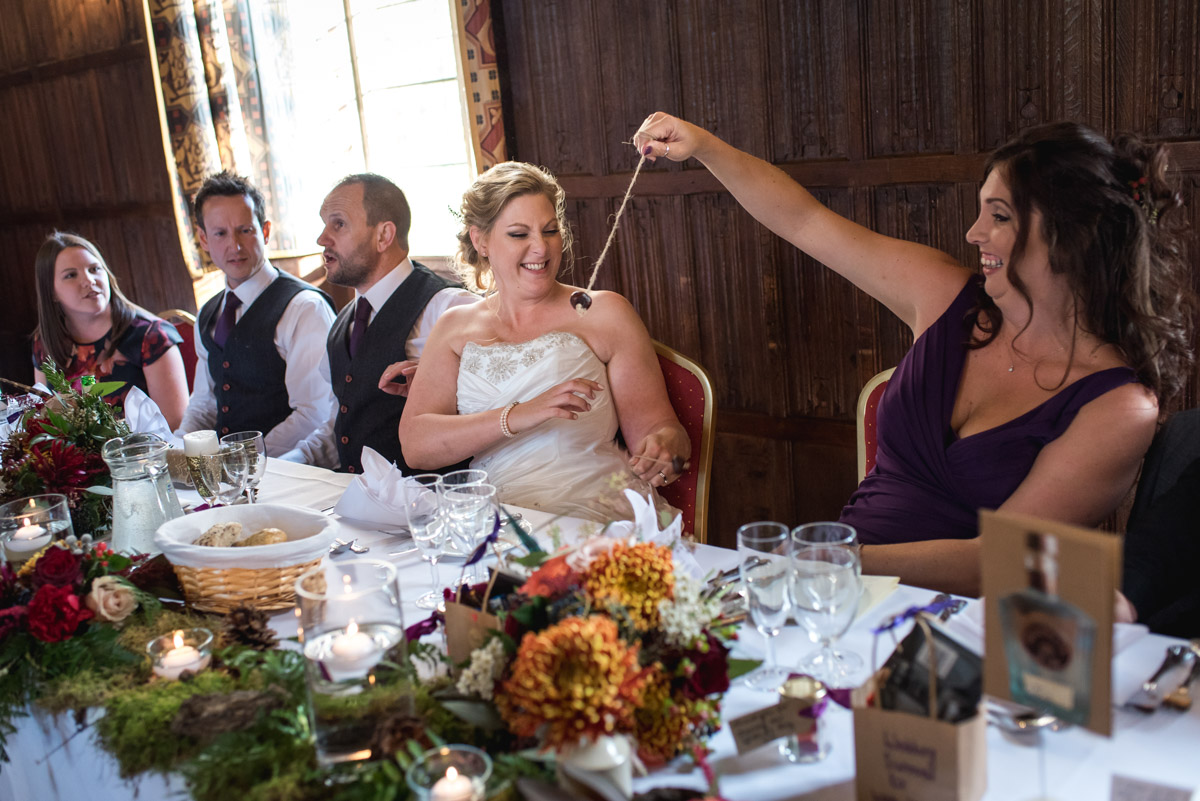 Lianne and her bridesmaid are photographed playing conkers during the reception at Lympne Castle in Kent
