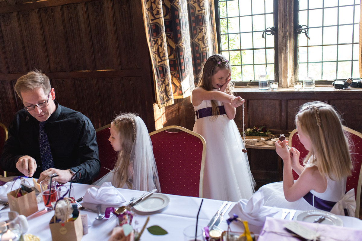 Flower girls are photographed playing conkers during Lianne and Johns Kent wedding at Lympne Castle In Kent