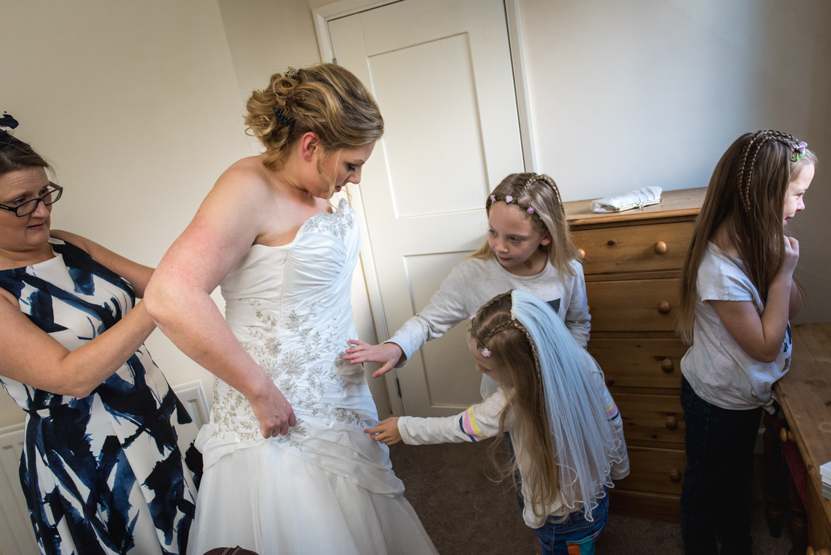 Flower girls inspect Liannes dress while she gets ready for her wedding at Lympne Castle in Kent