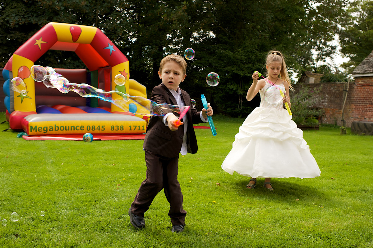 children play with bubbles on the wedding day party in Kent