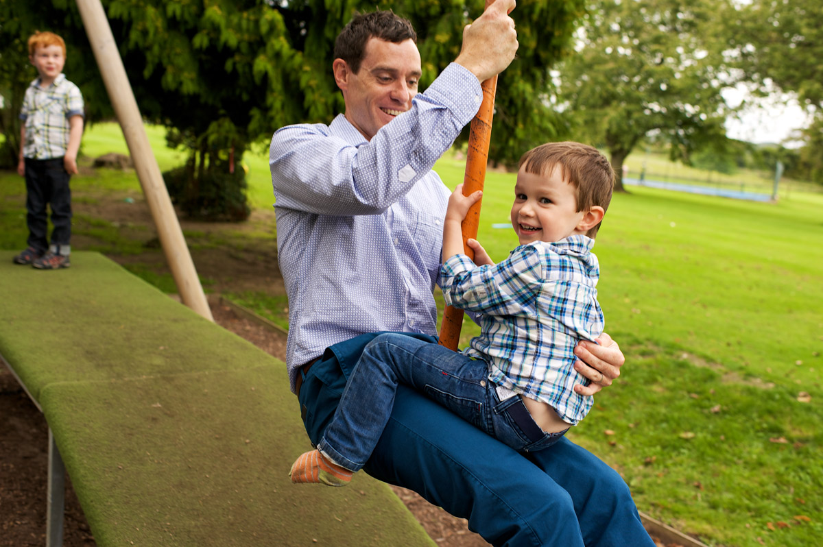 father and son on the swing at wedding day celebration in Kent
