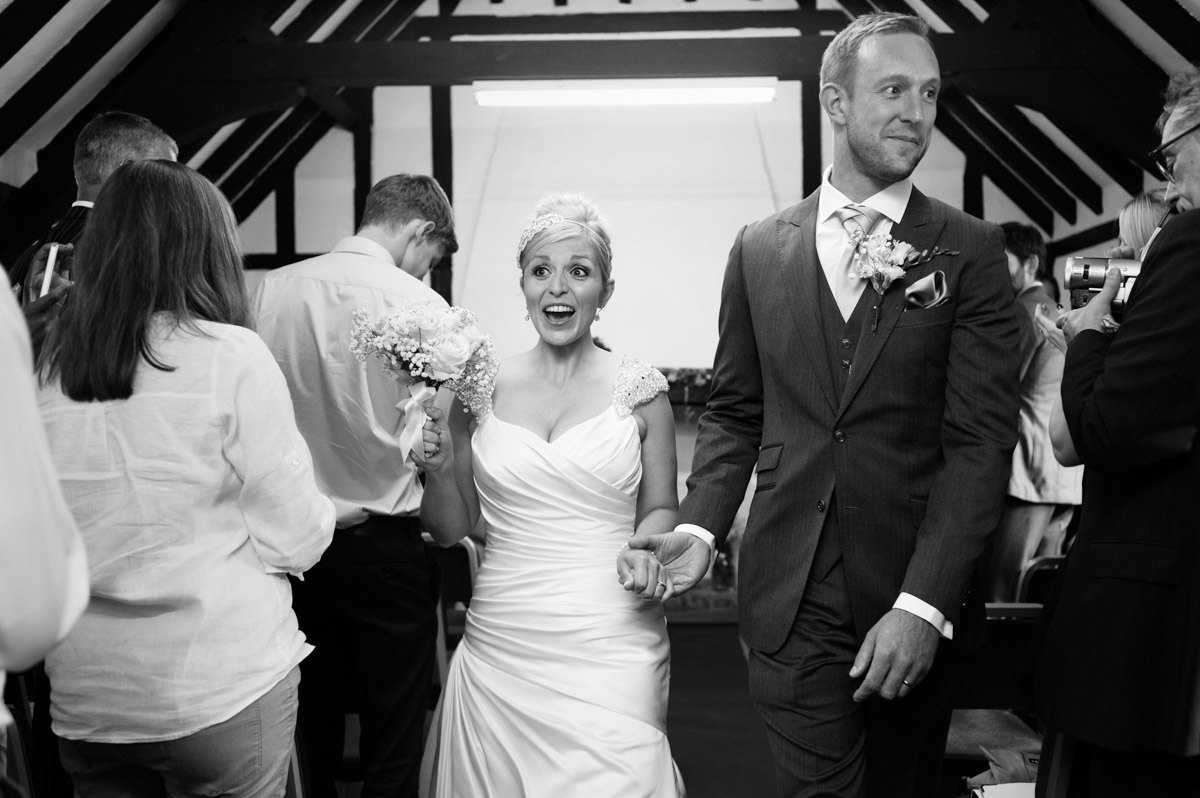 Emily and Rob walk back down the aisle after their wedding in Kent