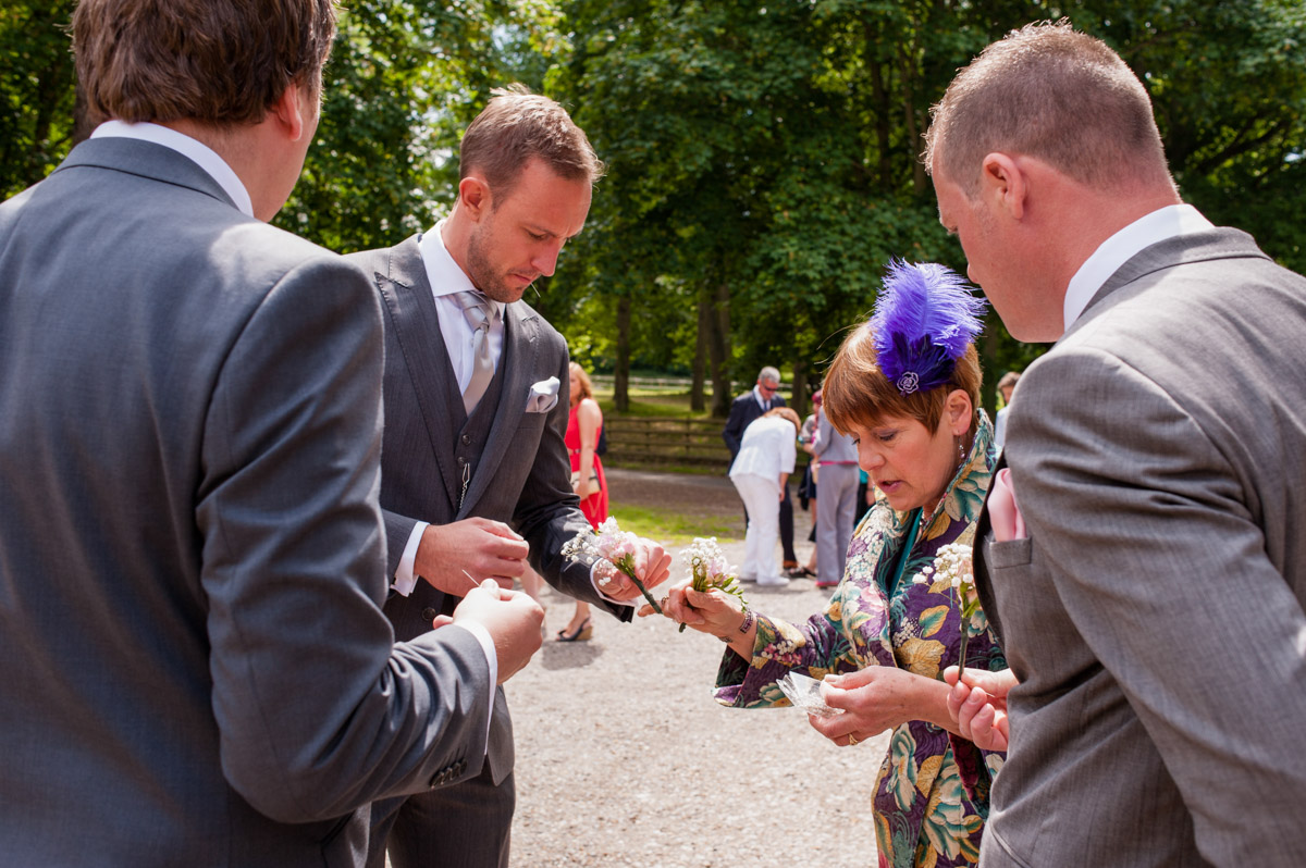 Photograph of Rob and groomsmen handing round button holes