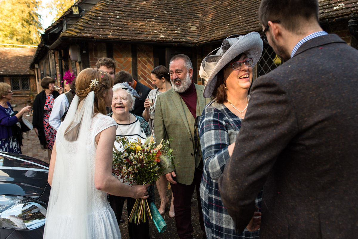 wedding guests at Chilham Village hall congratulate laura and Paul