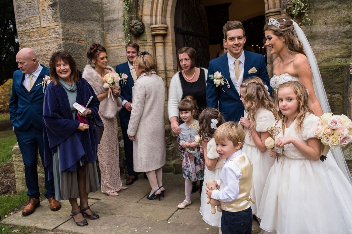 Jade and Stuart photographed with flower girls and page boy outside Kilndown church