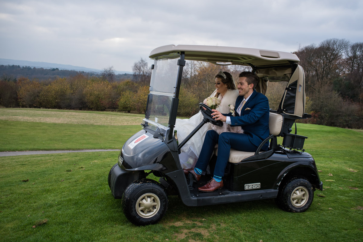 Photograph of Jade and Stuart driving golf buggy at their wedding reception