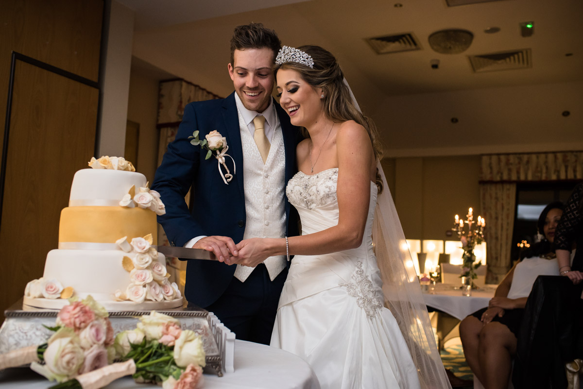Jade and Stuart are photographed cutting their wedding cake
