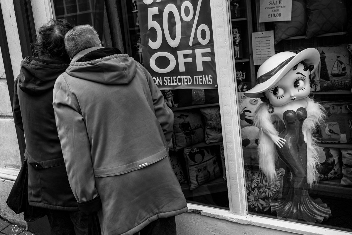 Black and white street photograph of Betty Boo and two ladies looking in shop window