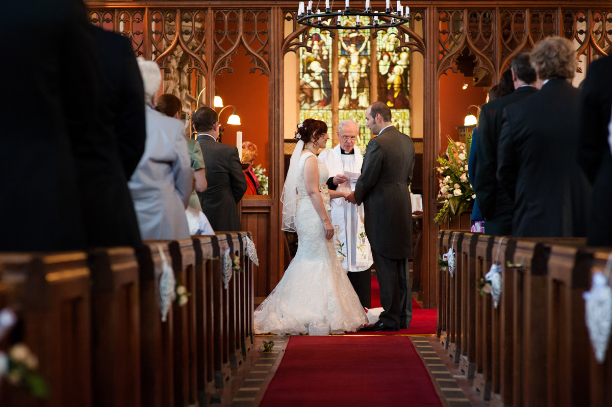Photograph of Chris and Charlotte exchanging rings during their Kent church wedding