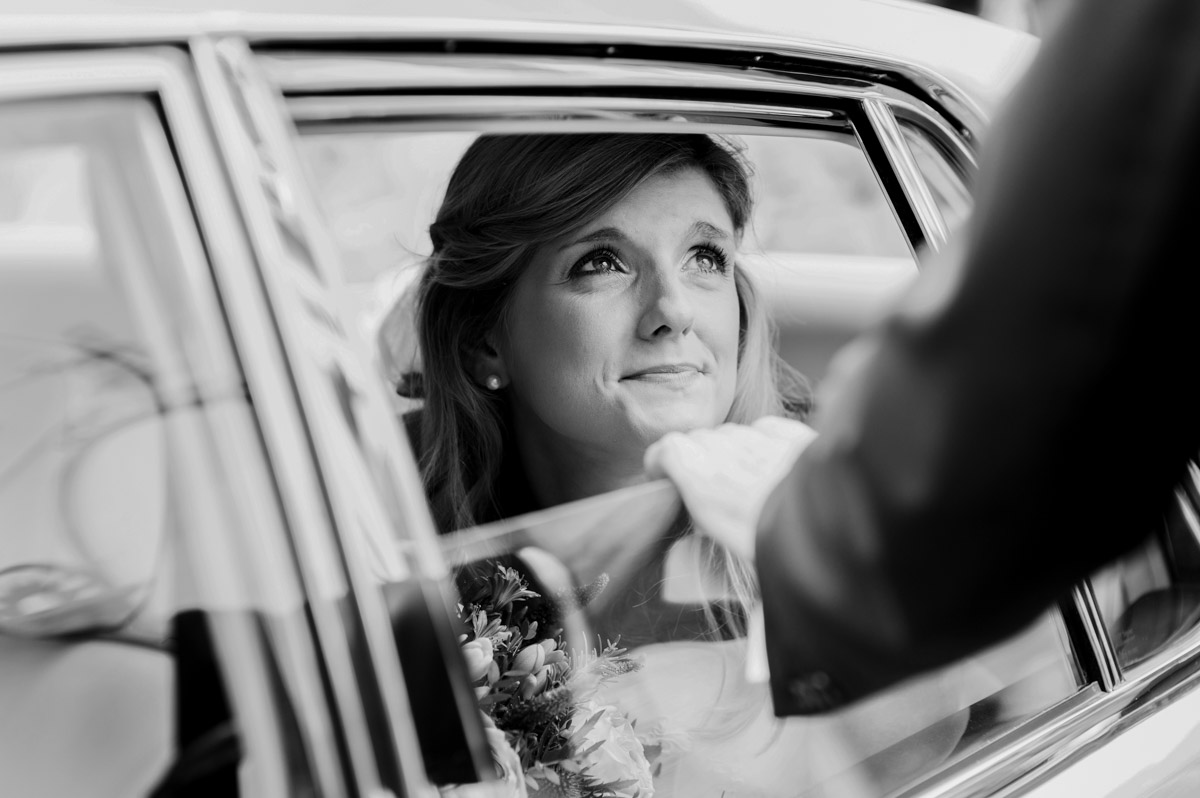 Black and white photograph of Heidi arriving in the car for her wedding in Canterbury Kent