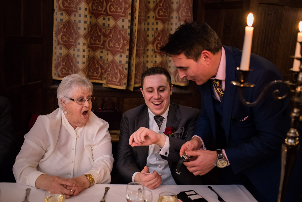 Magician photographed doing tricks at Sue and Nicks Christmas wedding