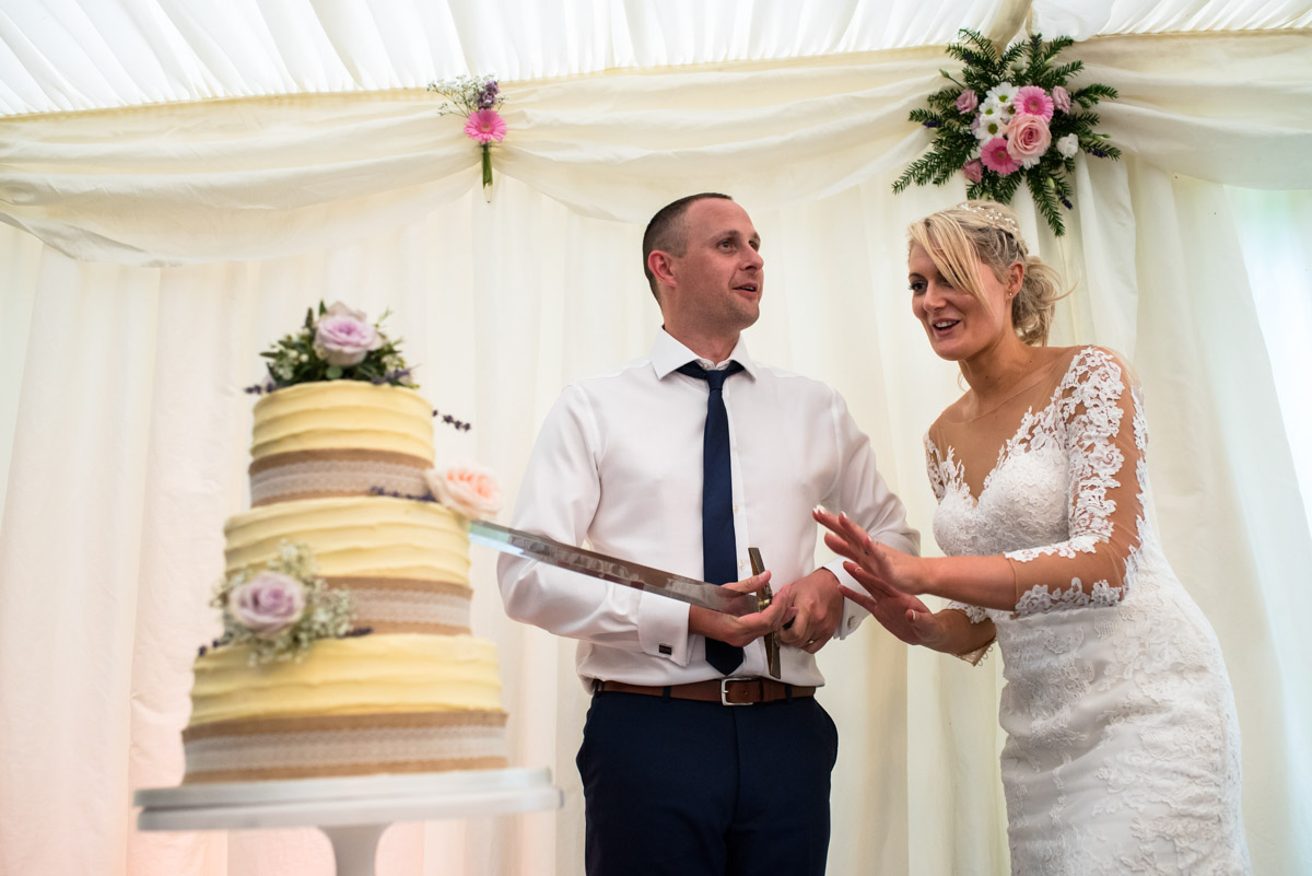 Lexy and Paul about to cut the wedding cake at their Kent wedding at Allington castle