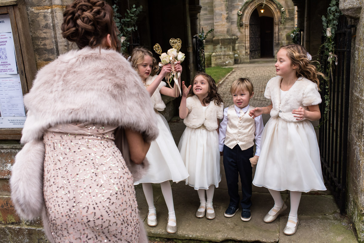 flower girls being given flowers before Jade and stuarts Kent church wedding