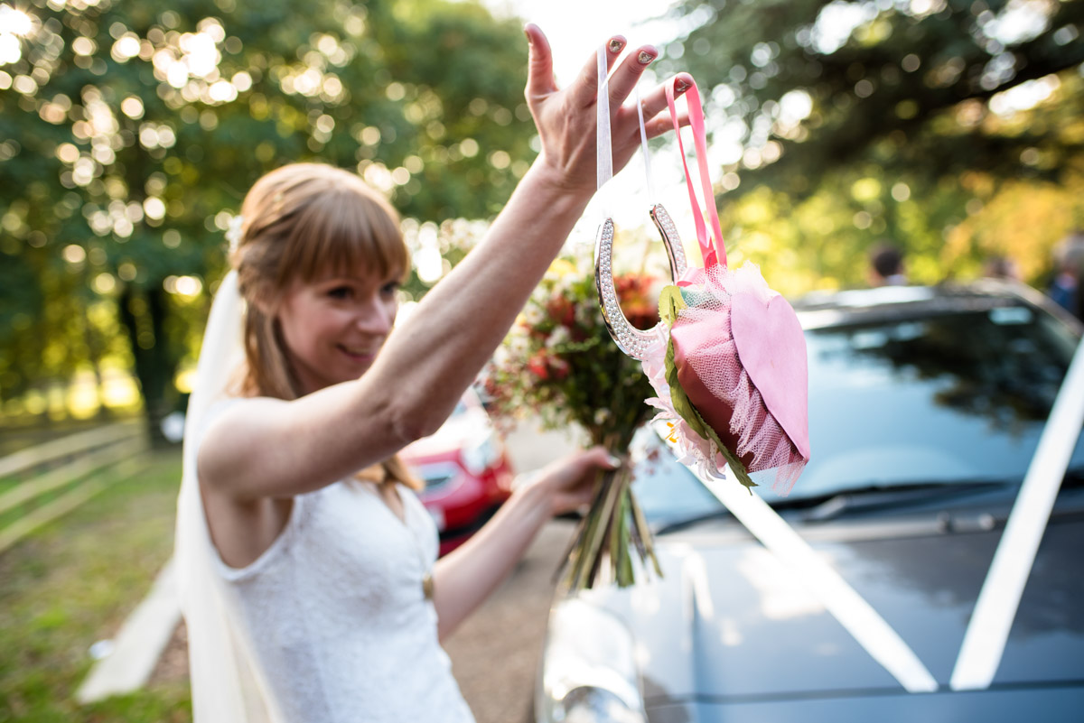 Laura photographed holding up wedding gifts at her Chilham village hall wedding