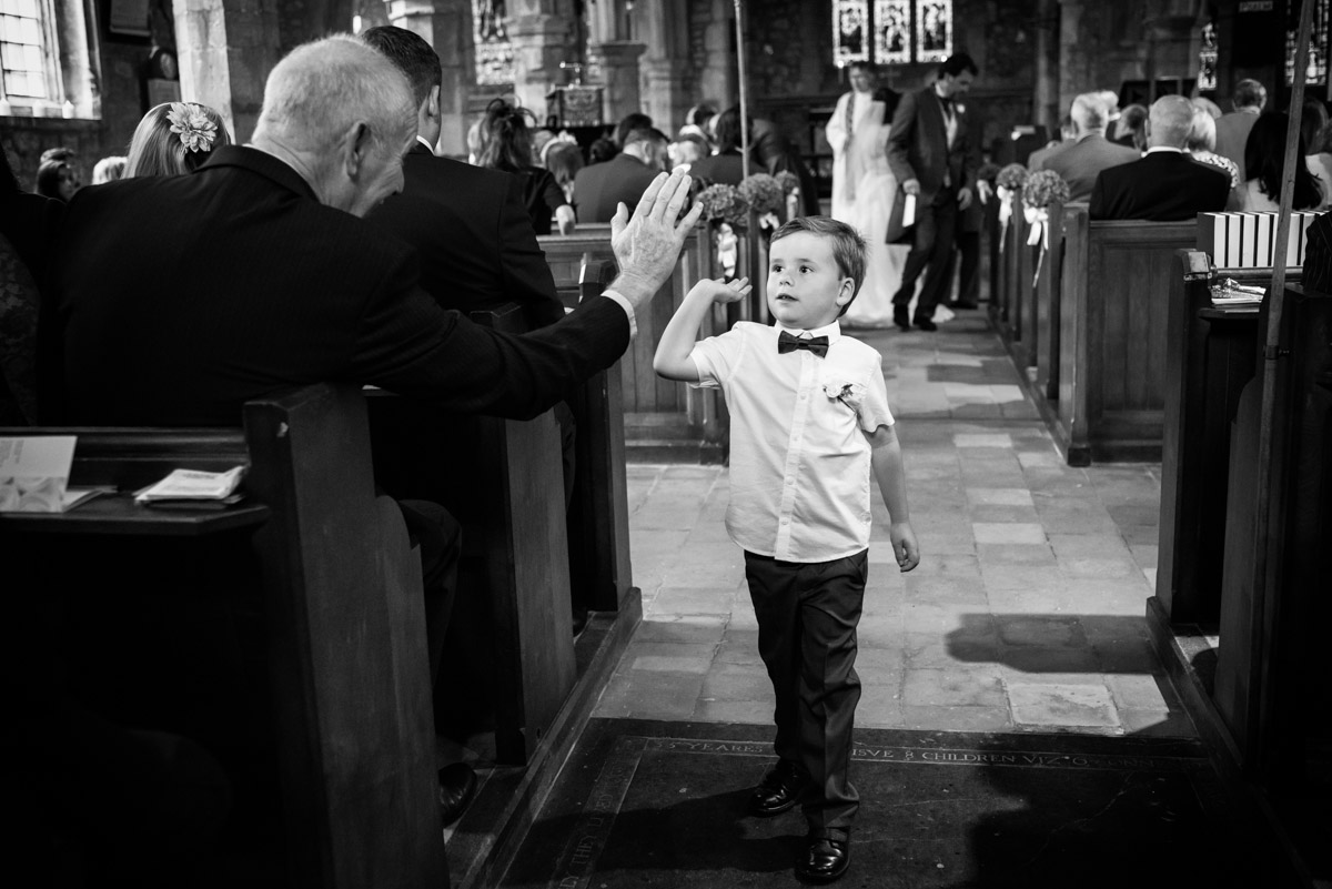 Pageboy high fives wedding guest at his parents wedding