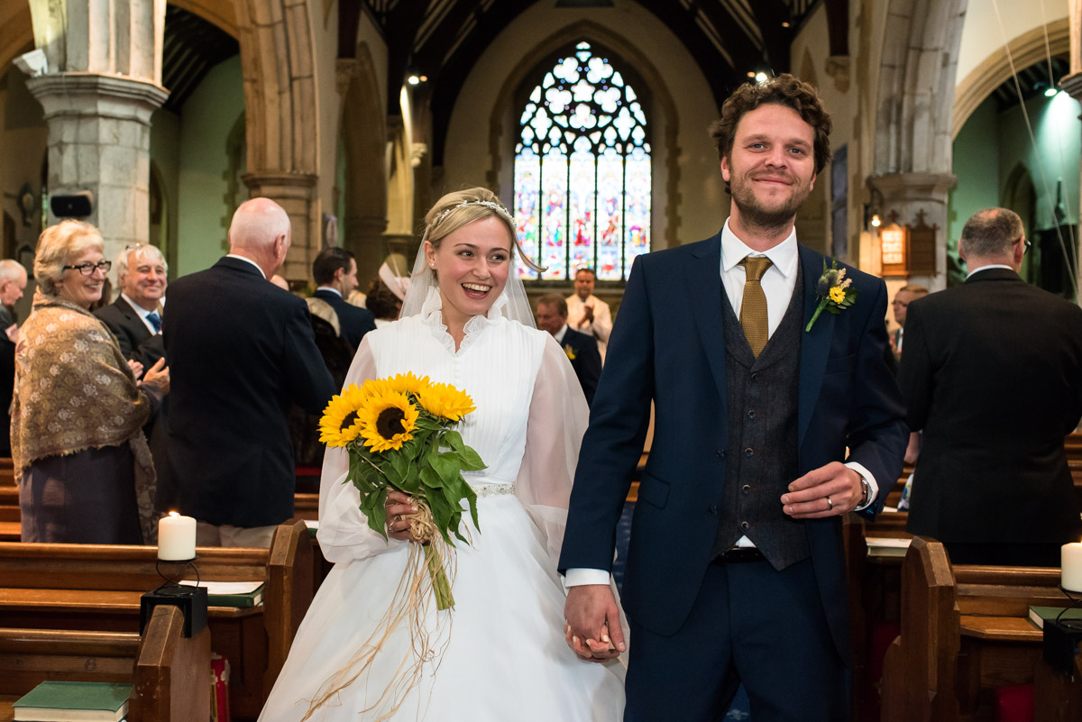 Photograph of Steven and Jane walking down the aisle after their chilham church wedding ceremony