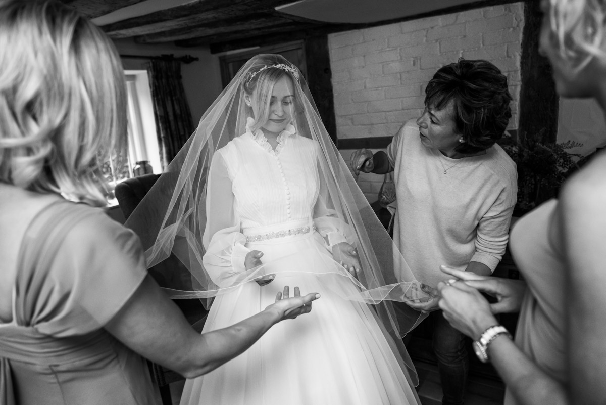 Photograph of Marissa and bridesmaids helping Jane with her veil on her wedding day