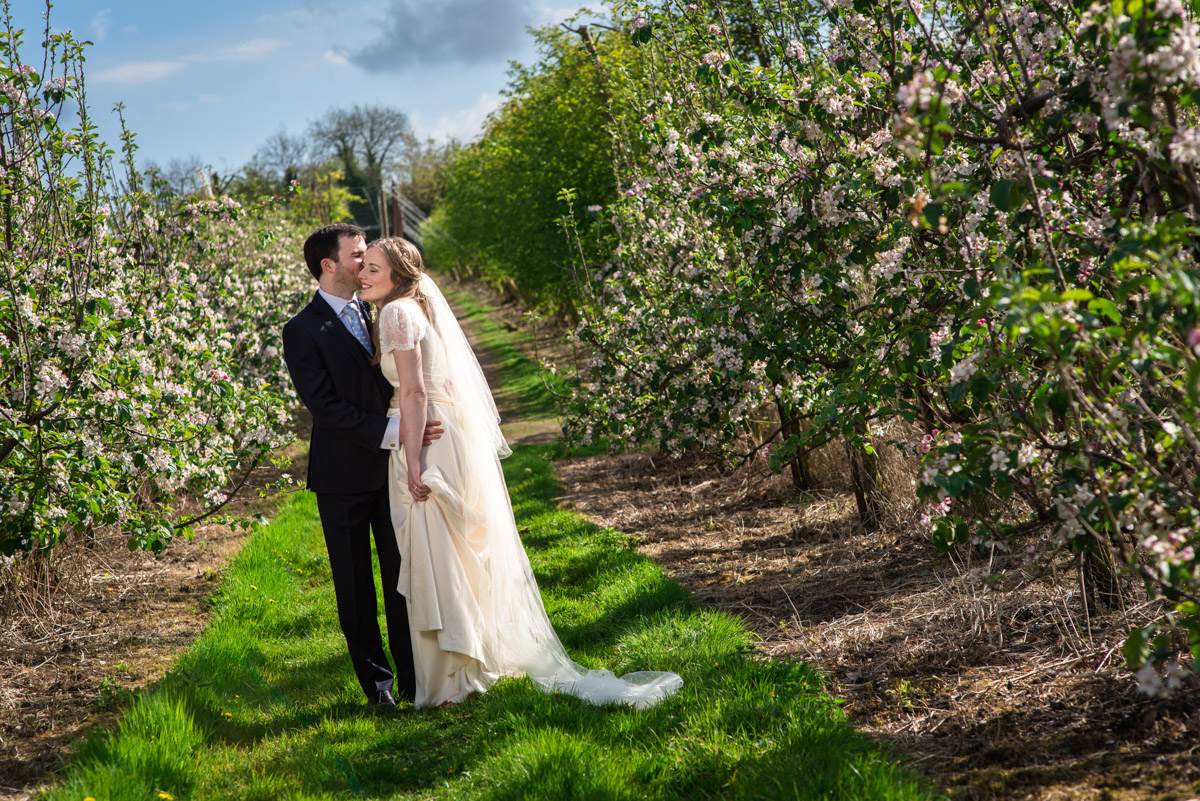 Wedding couple photograph of Flora and James in apple orchards in Brenchley Kent