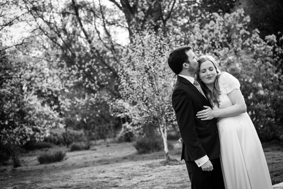 Black and white photograph of Flora and James in the garden of their wedding reception