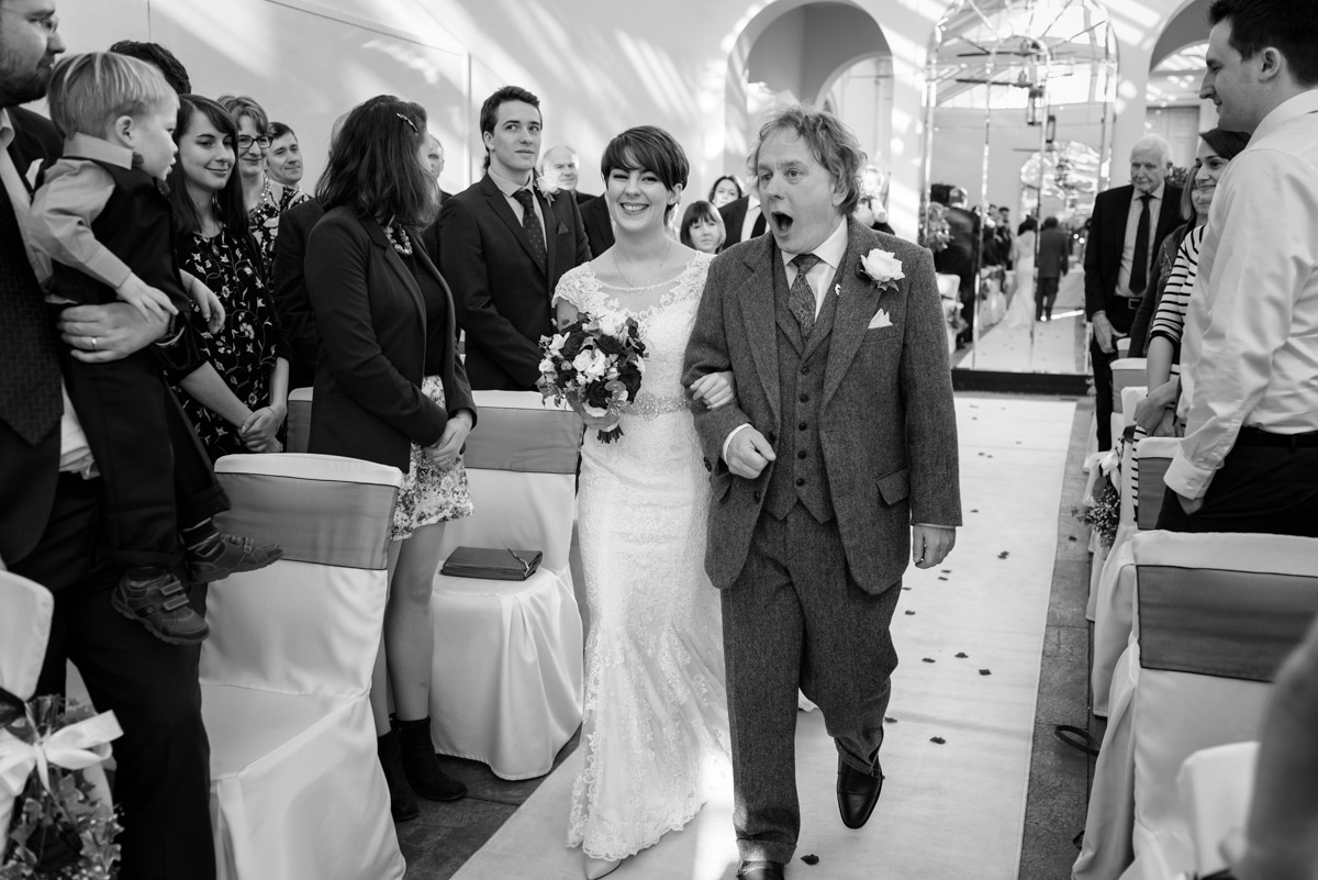 Father and daughter walk down the aisle at Buxted park Hotel wedding