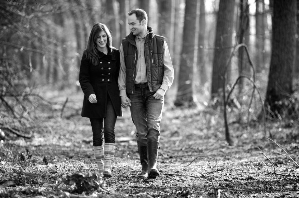 Black and white relaxed and natural pre wedding photography of Julia and Ryan walking hand in hand