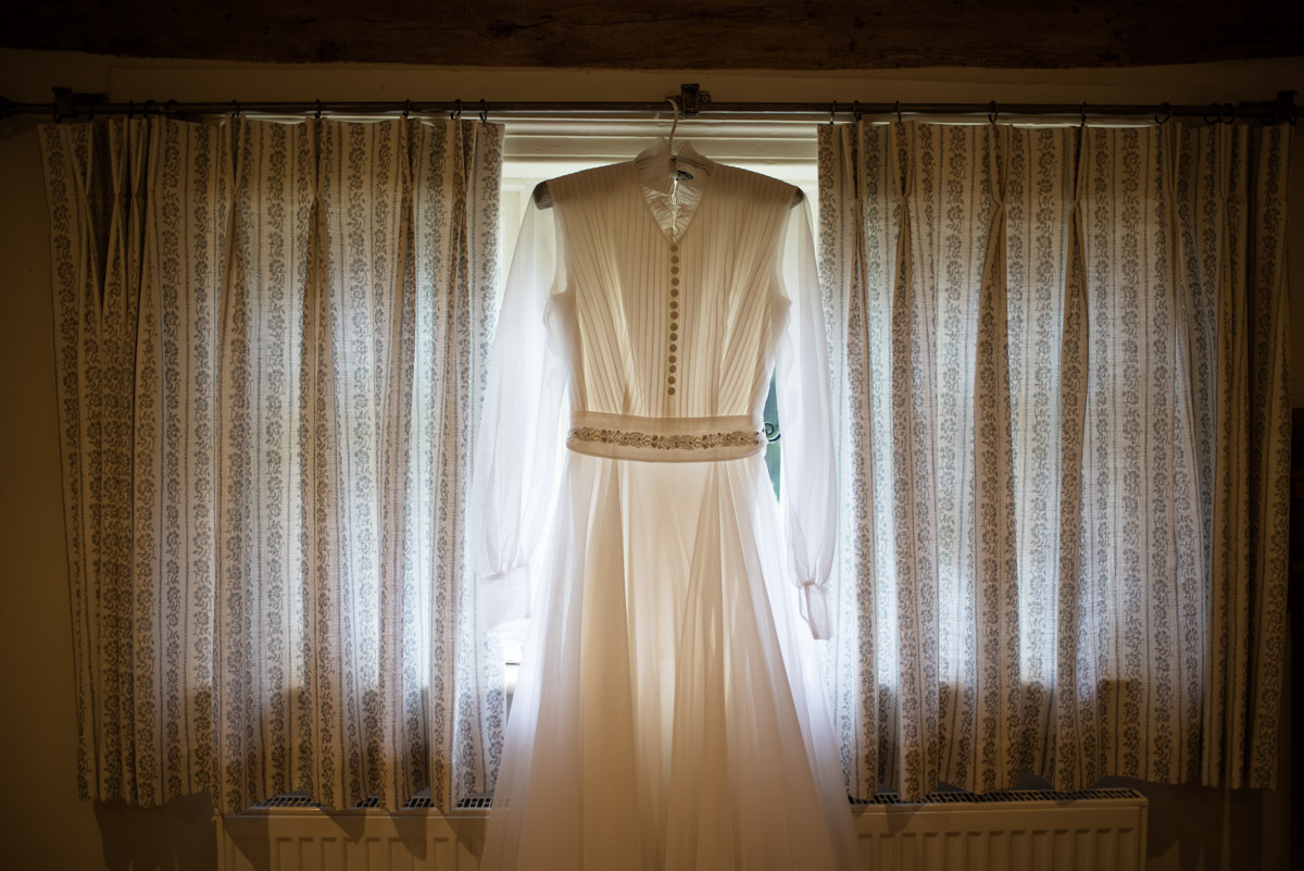 Photograph of Janes wedding dress hanging in the window
