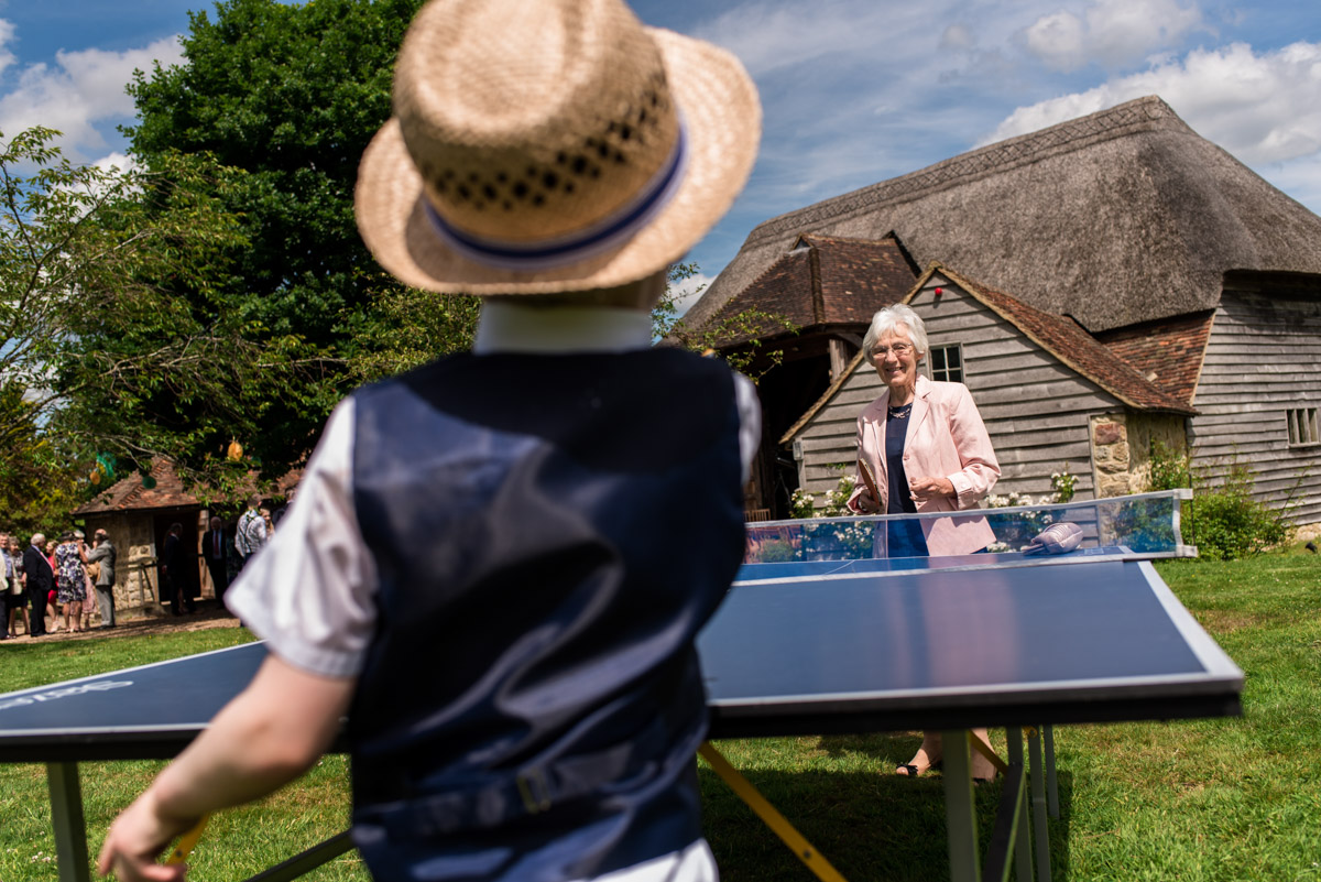 Wedding guests photographed playing table tennis in grounds at Ratsbury Barn