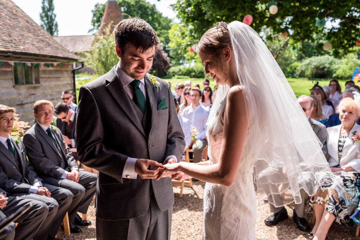 Tom places ring on Beths finger during Ratsbury Barn wedding in Kent