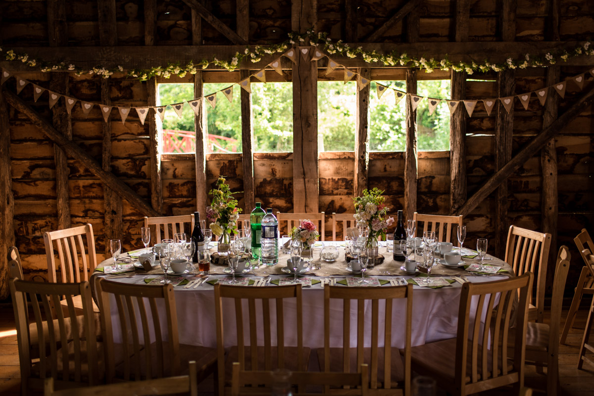 Photograph of top table inside Ratsbury Barn in Kent on Tom and Beths wedding day