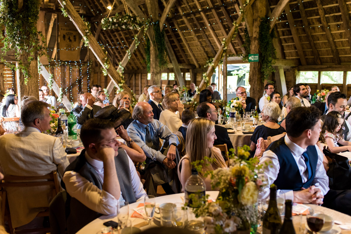 Photograph of wedding guests in Ratsbury Barn during Tom and Beth's reception