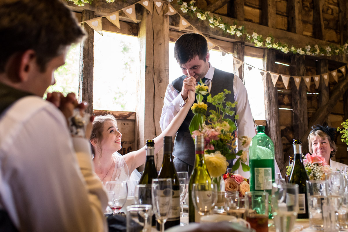 Tom kisses Beths hand after making his wedding speech at Ratsbury barn in Kent