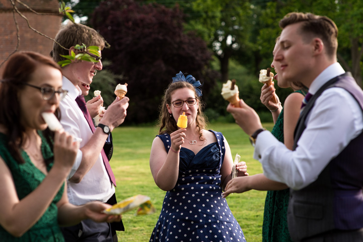 Wedding guests photographed eating ice creams at beth and Toms Ratsbury Barn wedding in Kent