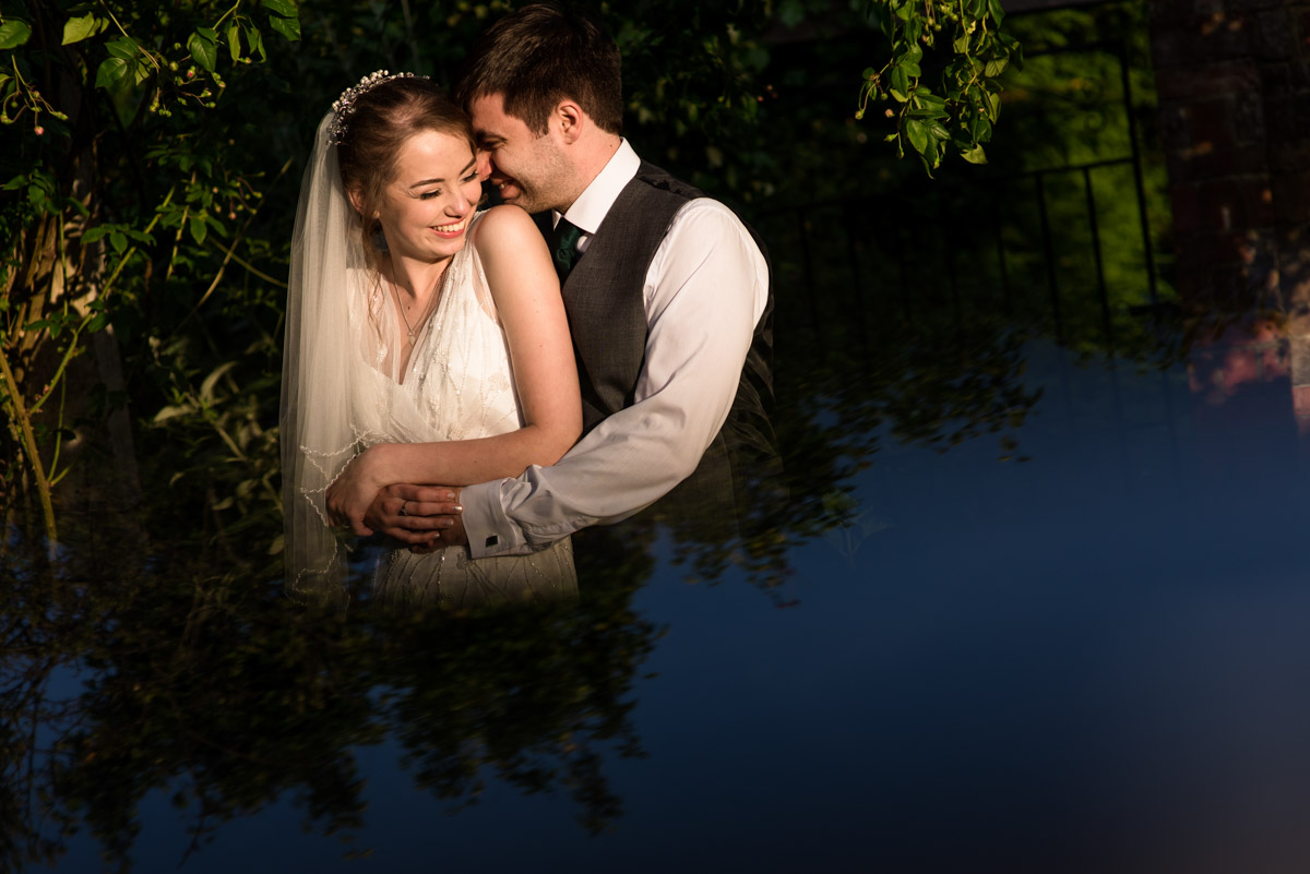 Beth and Tom are photographed embracing during quiet moment together after their wedding at Ratsbury Barn