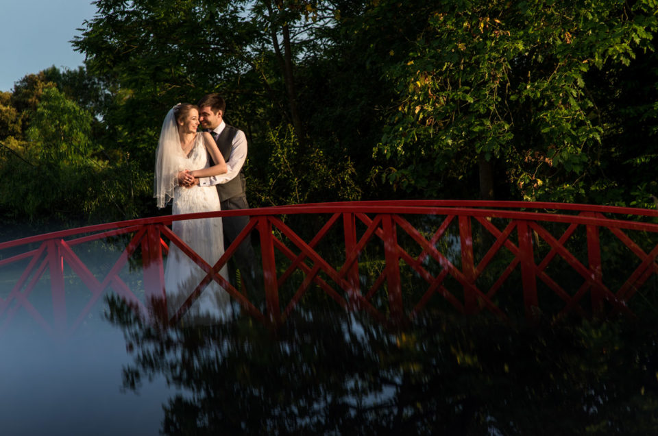 Beth and Tom on red foot bridge, Ratsbury Barn photography in Kent