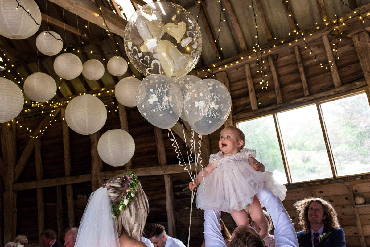 Photograph of baby and balloons at Anne and Joshs Kent summer wedding