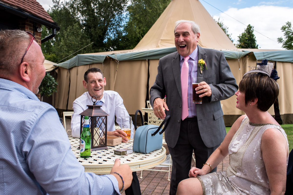 Debbie father laughing with other wedding guests