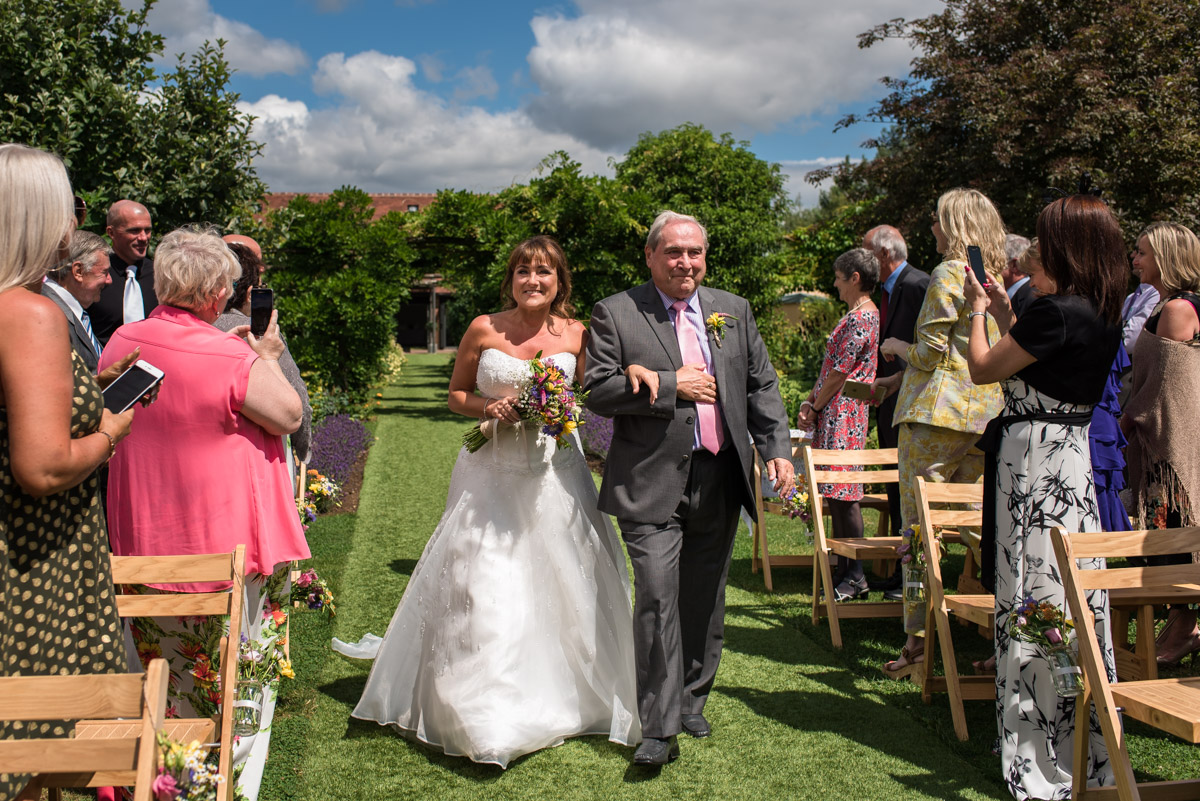 The Gardens Yalding wedding photography. Debbie being walked down the aisle by her father
