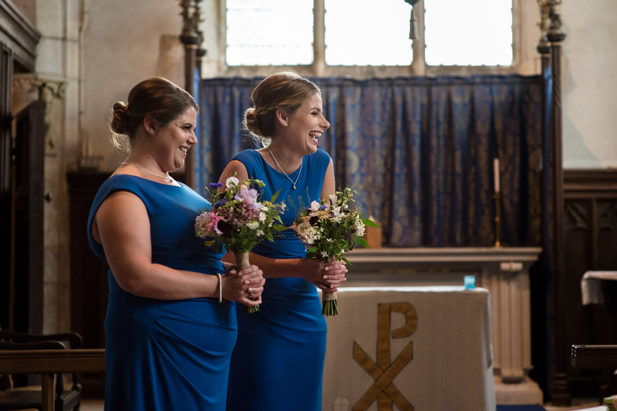 Photograph of bridesmaids laughing during church wedding