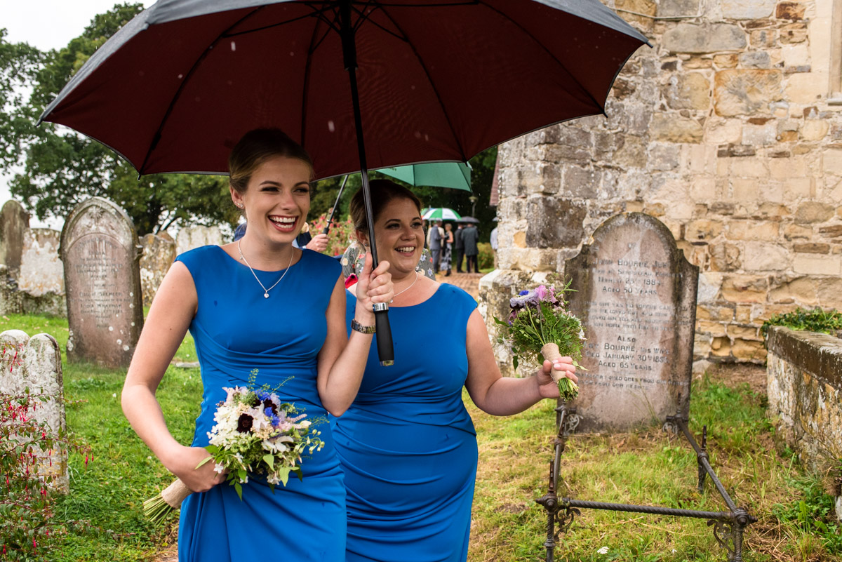 Photograph of bridesmaids under umbrellas