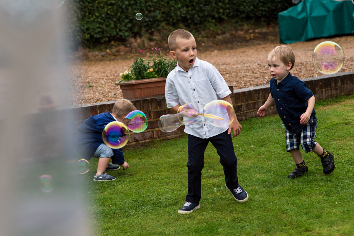 Boys playing with bubbles at emily and Toms east sussex wedding