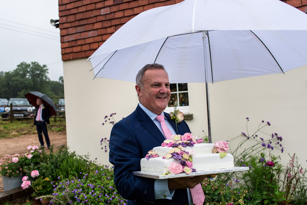 East sussex wedding photography, Emily's dad carrying wedding cake