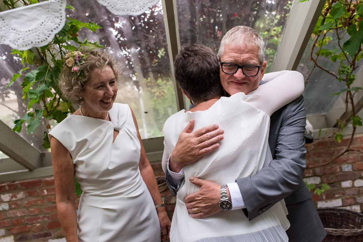 John is photographed hugging wedding guest after ceremony