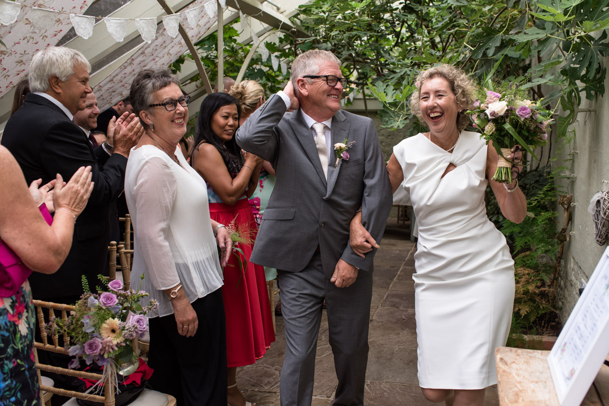 The Secret garden wedding photography of Kate and John dancing down the aisle