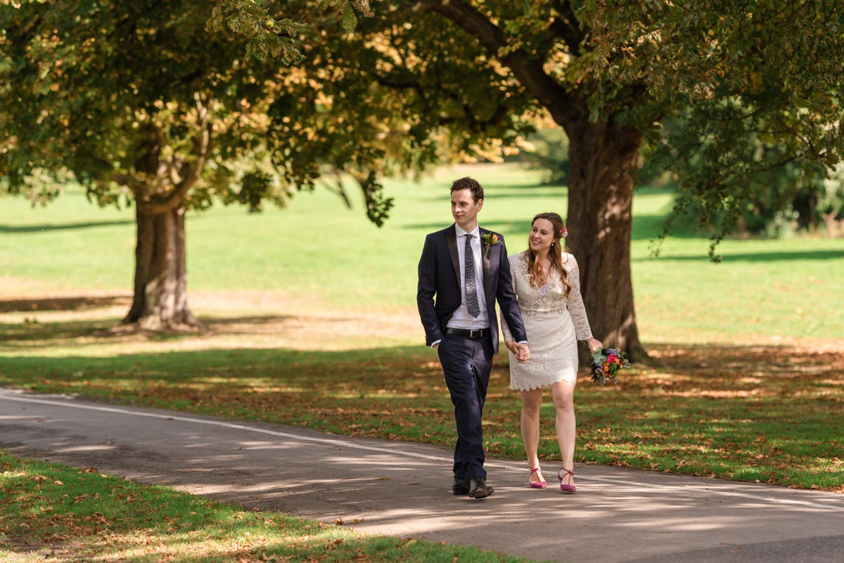 Alex and James are photographed in the park walking hand in hand