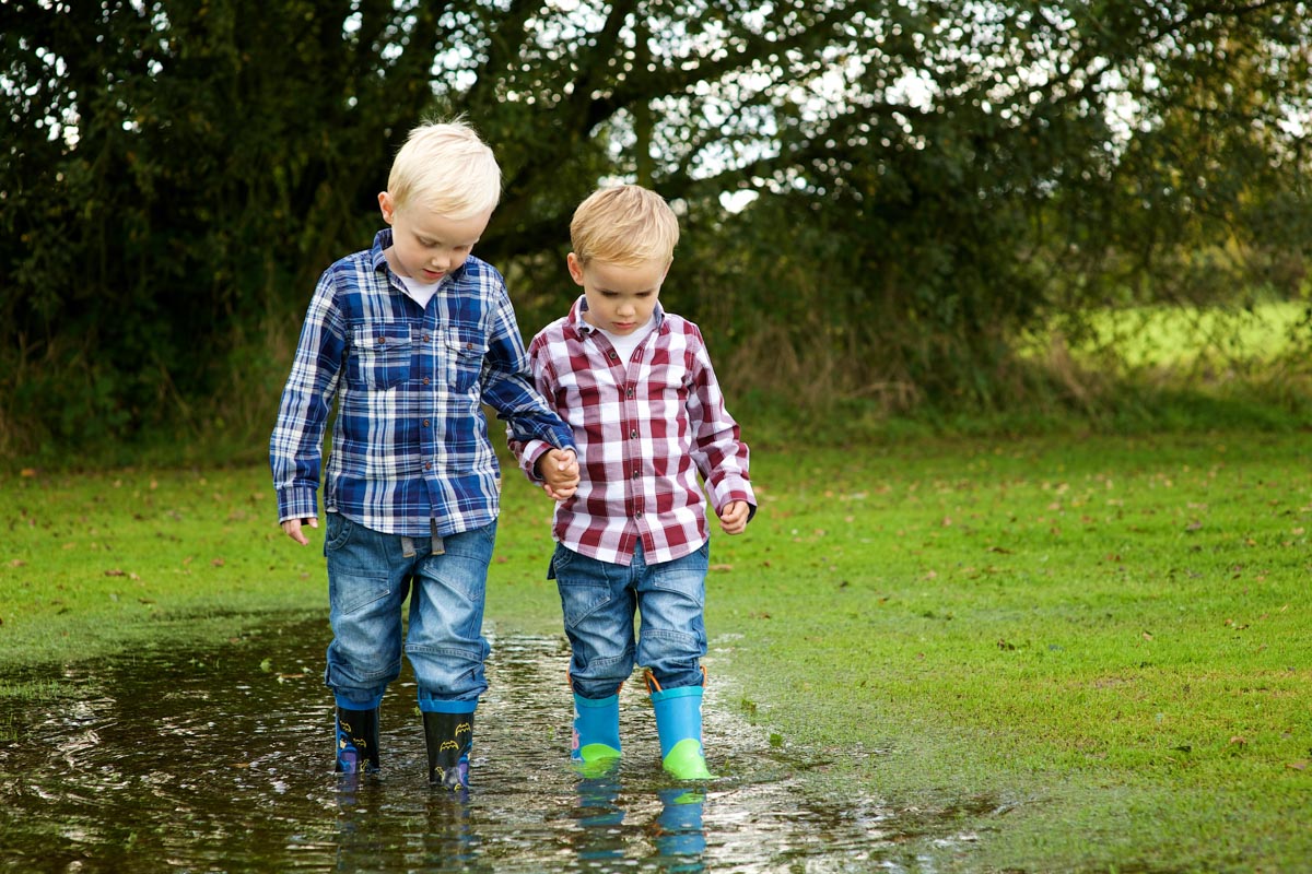 Portrait photograph of Harry and Jake in a puddle