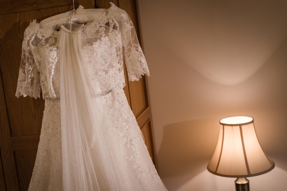 Photograph of Rebecca's wedding dress hanging in room at darling Buds farm