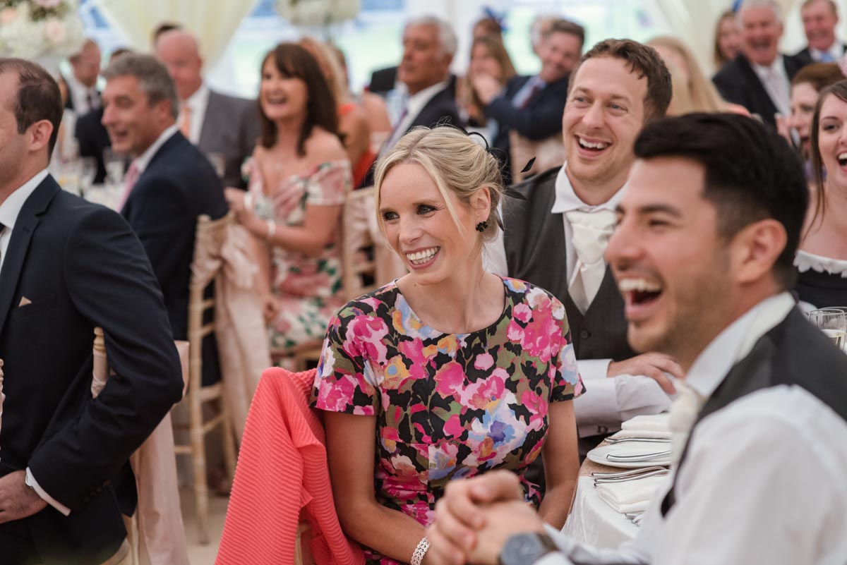 Photograph of guests laughing during wedding speeches in Kent