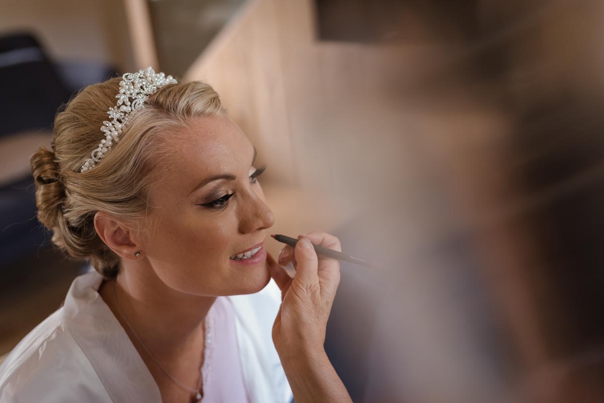 Rebecca is photographed having her make up done on her wedding day in Kent