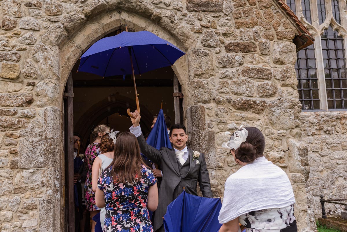 Photograph of usher with umbrella at wedding in Kent